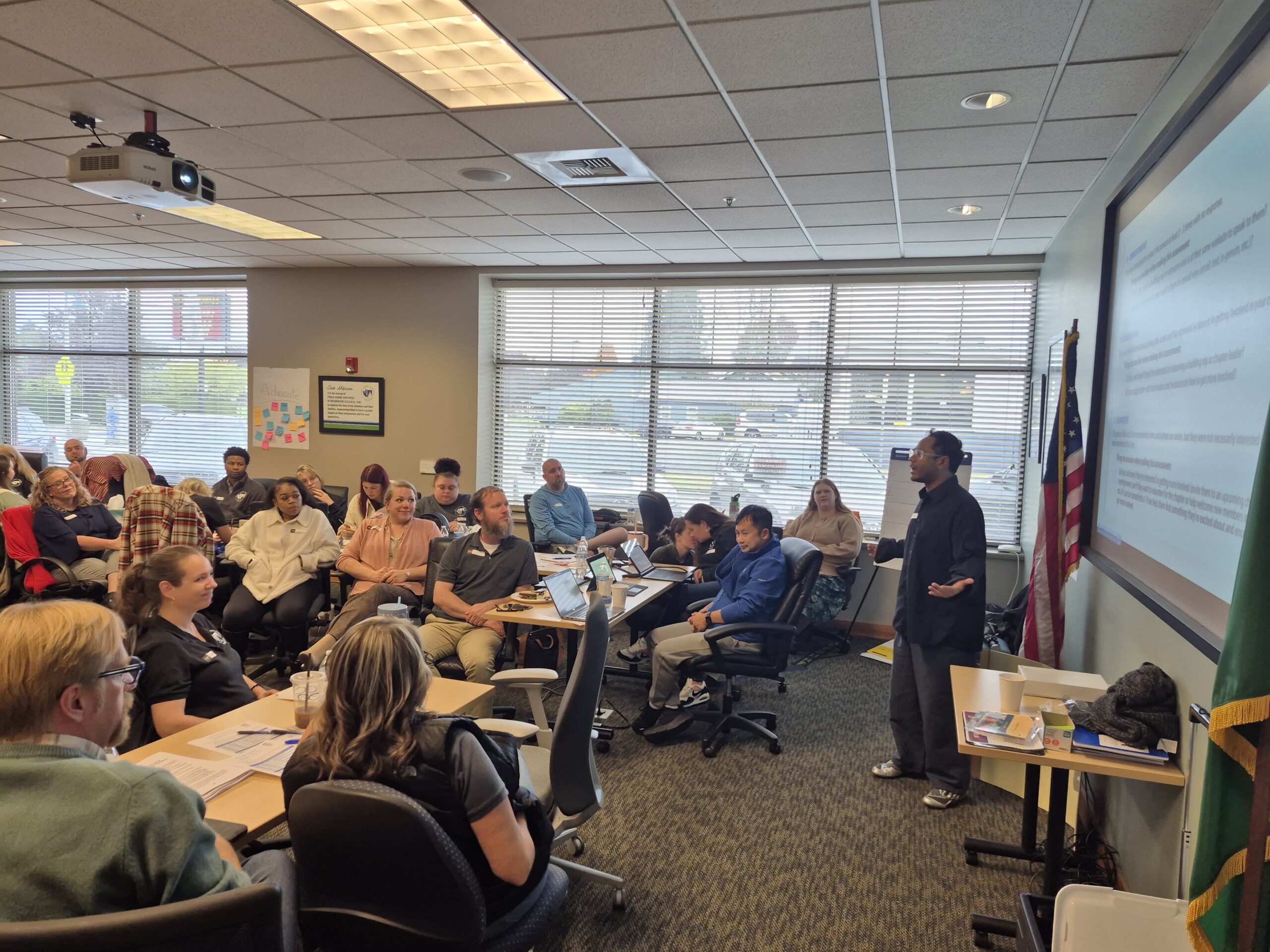 A speaker presents to a room of workers