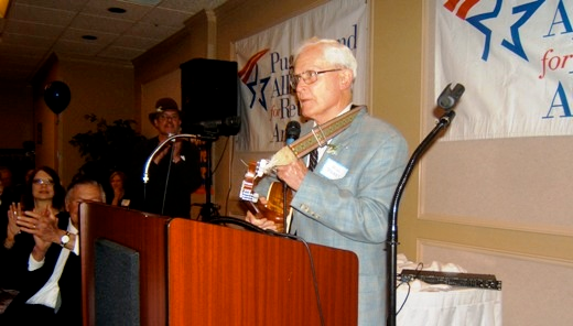 Will Parry speaking at a podium, 2010