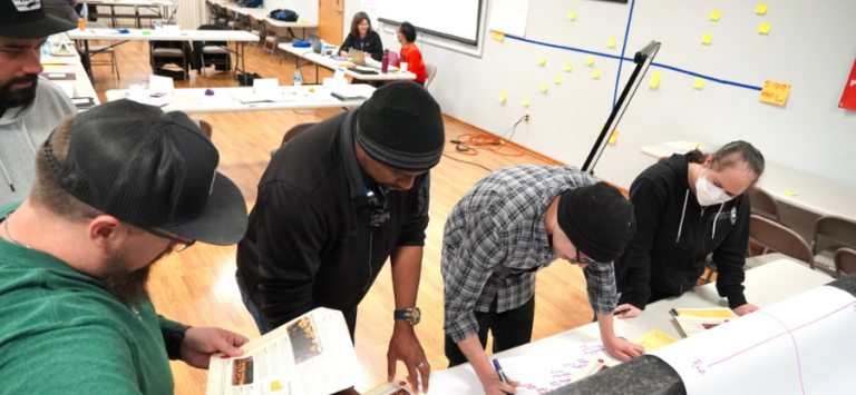 Workers gathered around a table during a workshop